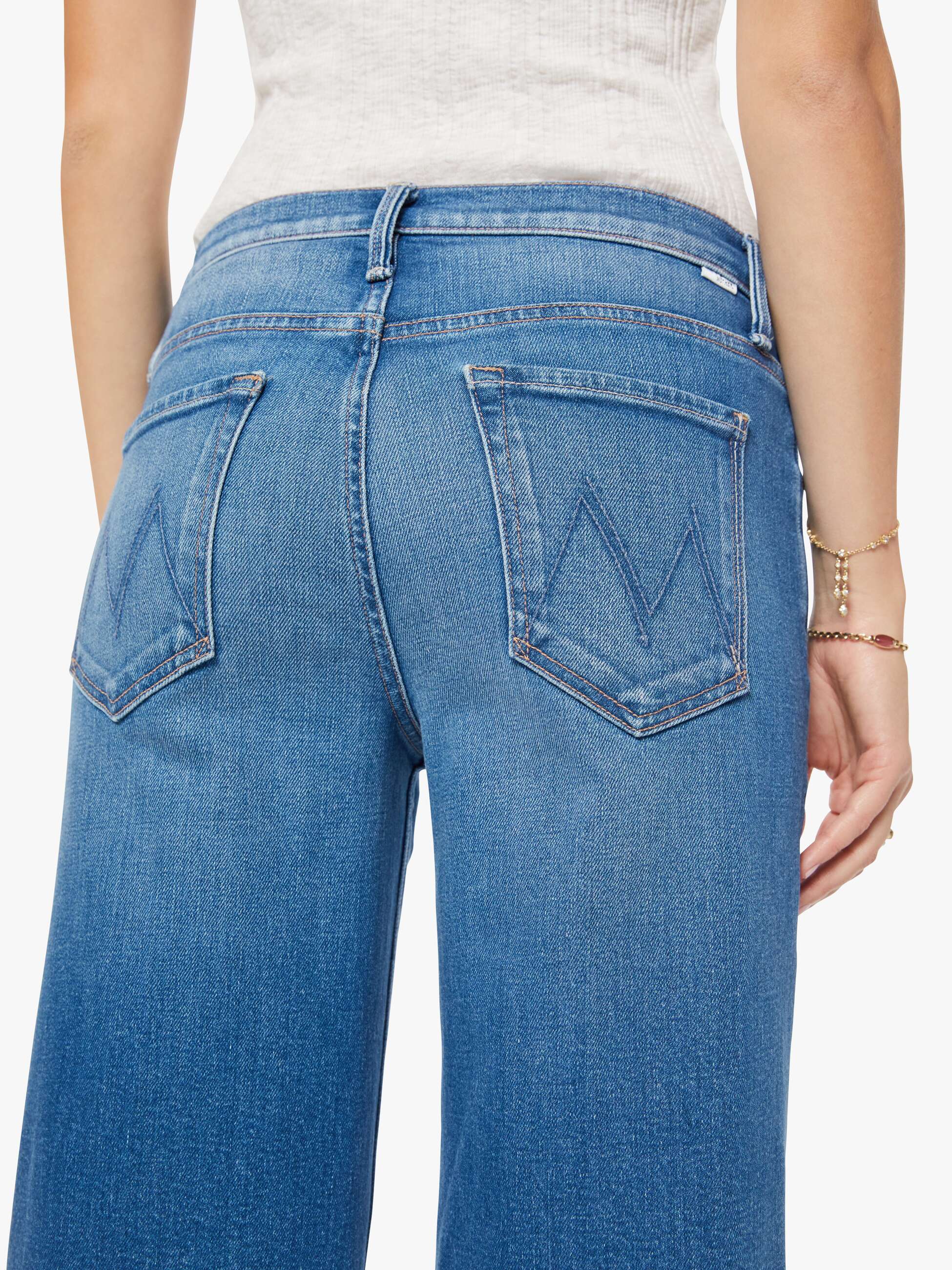 Blue jeans worn by a person on a white background