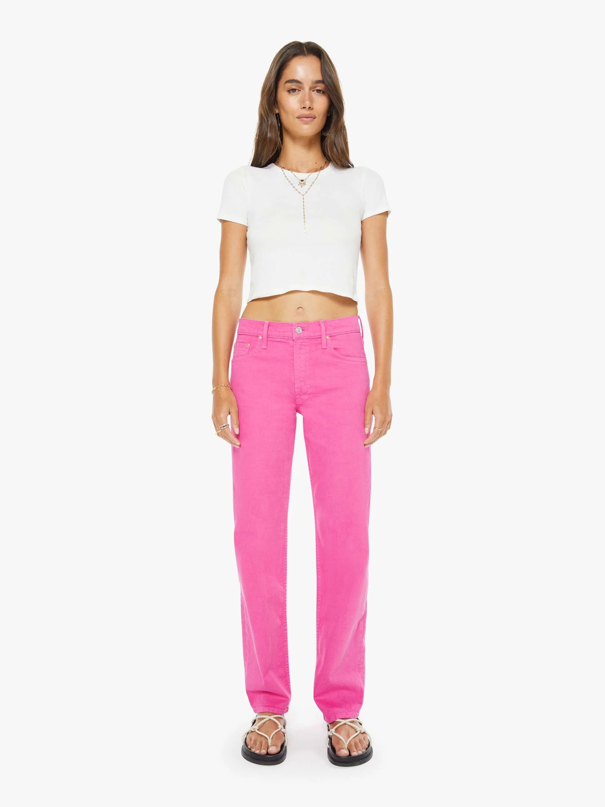 Woman wearing bright pink pants and a white top on a white background