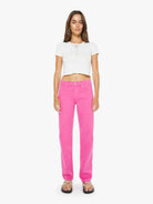 Woman wearing bright pink pants and a white top on a white background