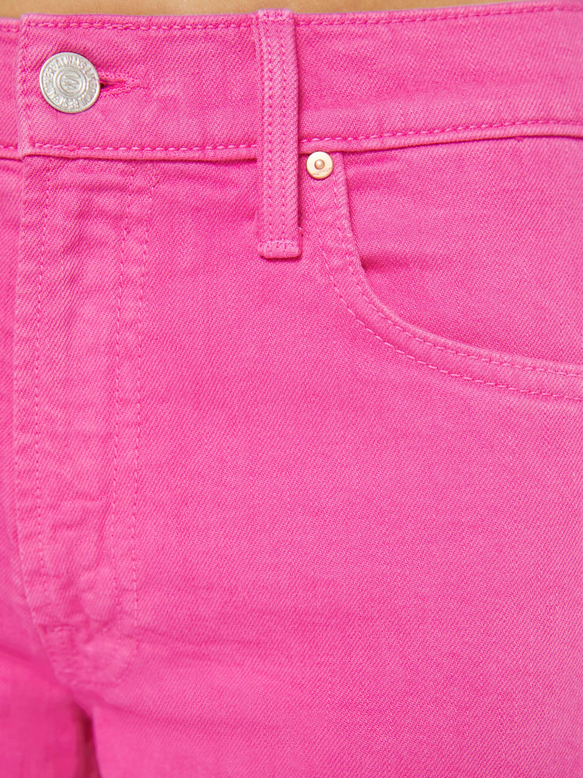 Close-up of bright pink denim fabric with a button and zipper.