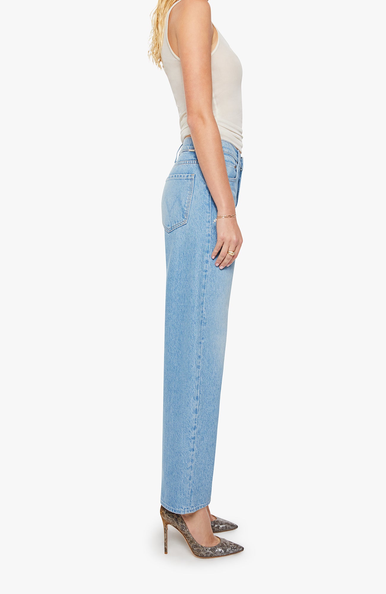 Woman wearing light blue jeans and a white top on a white background