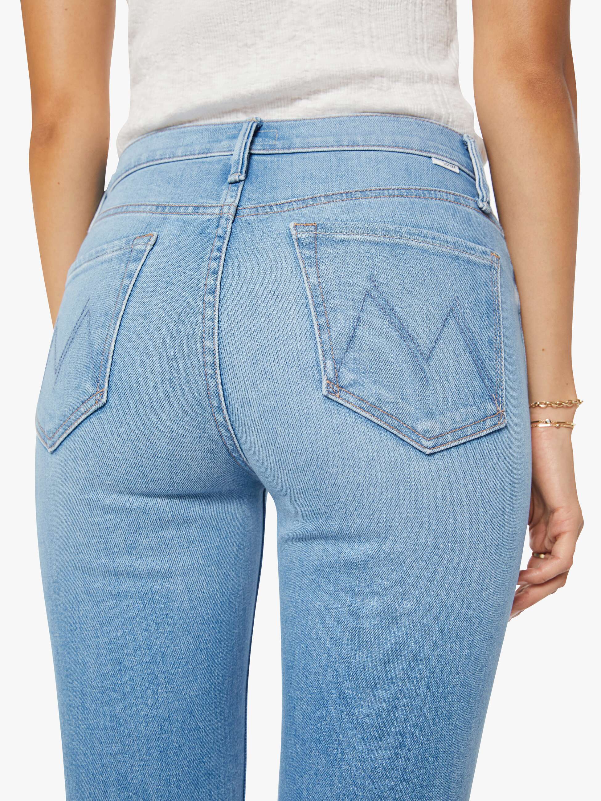 Light blue jeans worn by a person on a white background