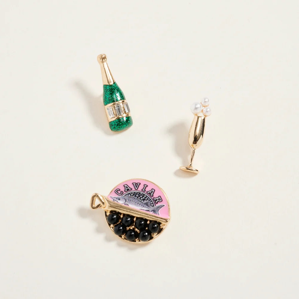 Three decorative earrings on a light beige background