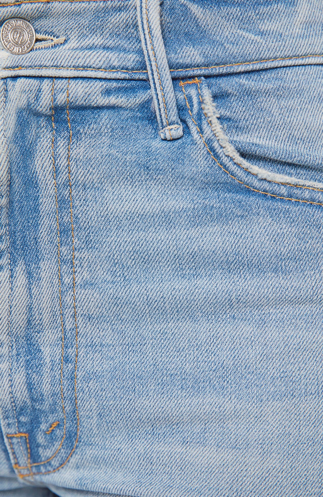 Close-up of blue denim jeans with a brand logo on the pocket.