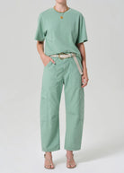 Person wearing a mint green t-shirt and cargo pants on a white background