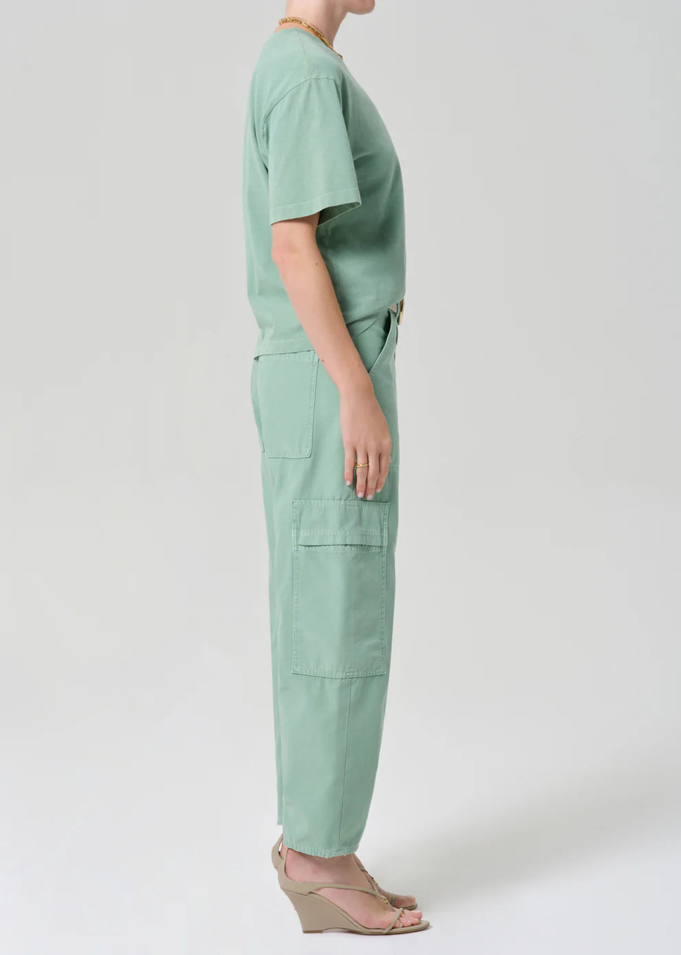 Person wearing a mint green outfit on a white background