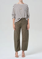 Person wearing a striped shirt and cargo pants on a white background