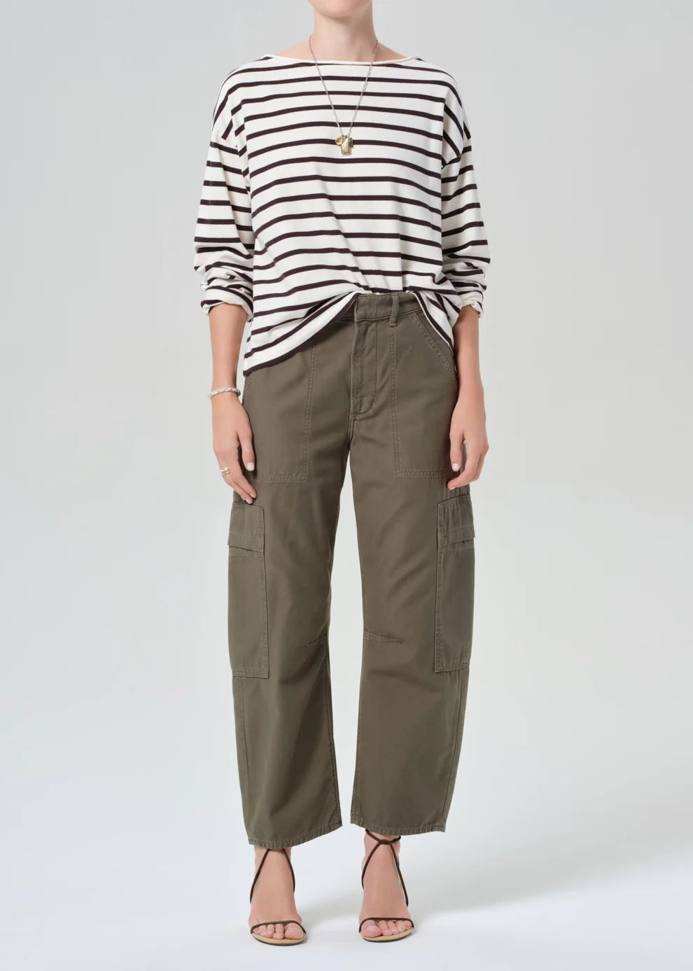 Person wearing a striped shirt and cargo pants on a white background