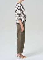Person wearing a striped sweater and cargo pants on a white background