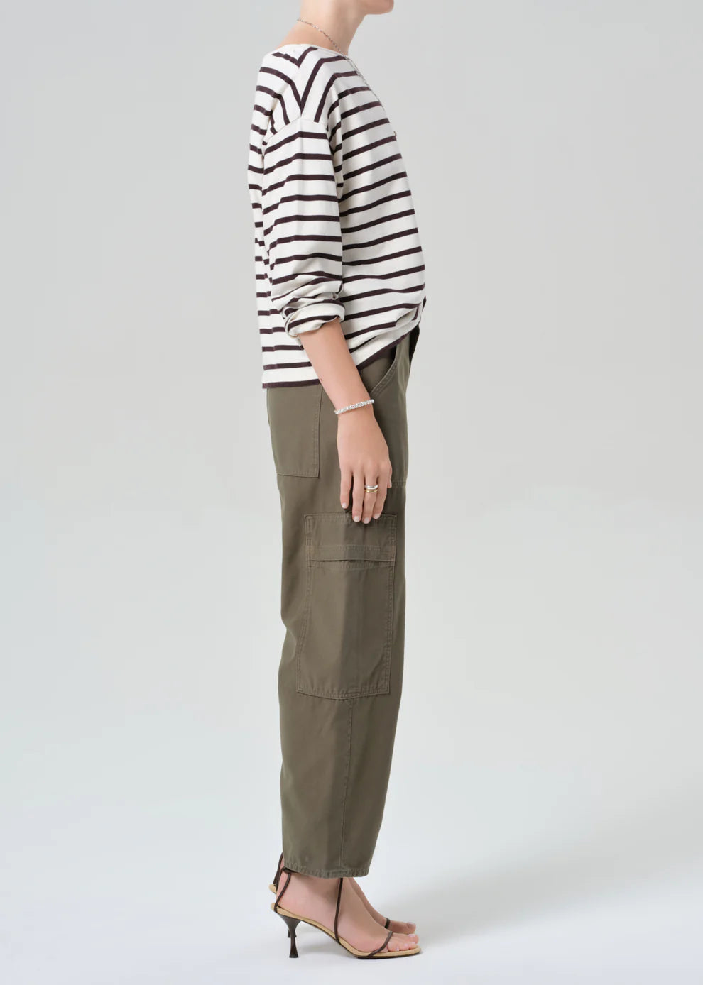 Person wearing a striped sweater and cargo pants on a white background