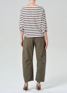Person wearing a striped shirt and cargo pants on a white background