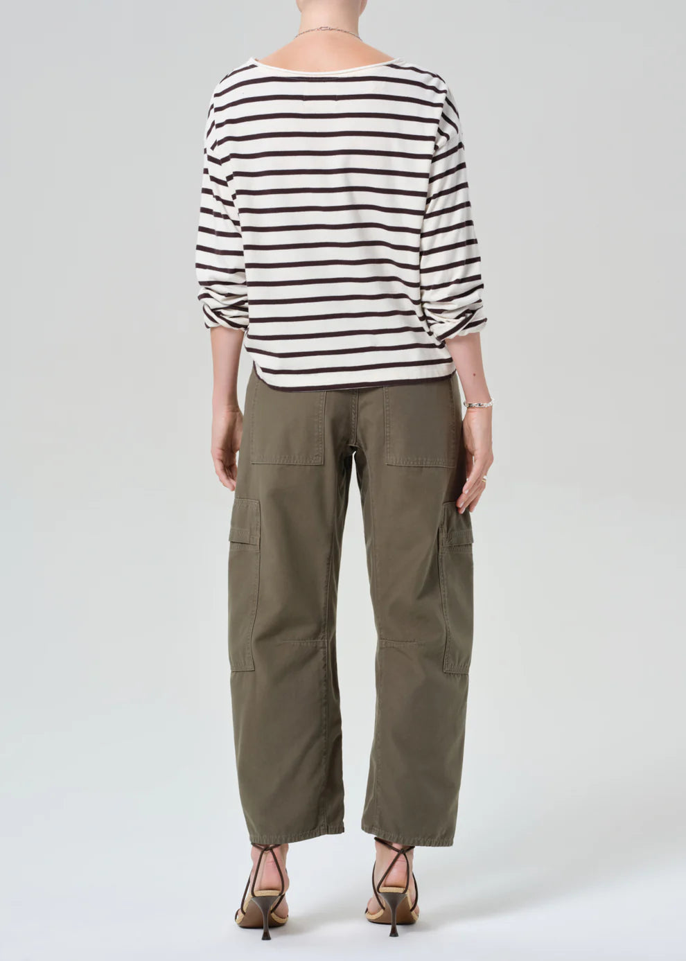 Person wearing a striped shirt and cargo pants on a white background