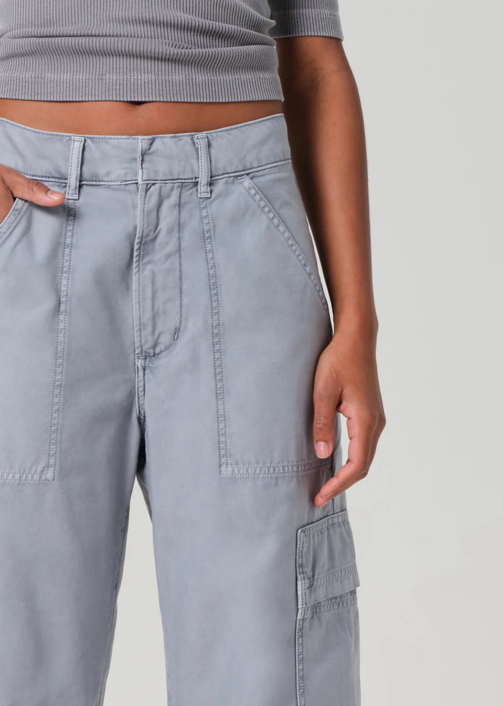 Gray cargo pants worn by a person on a plain background