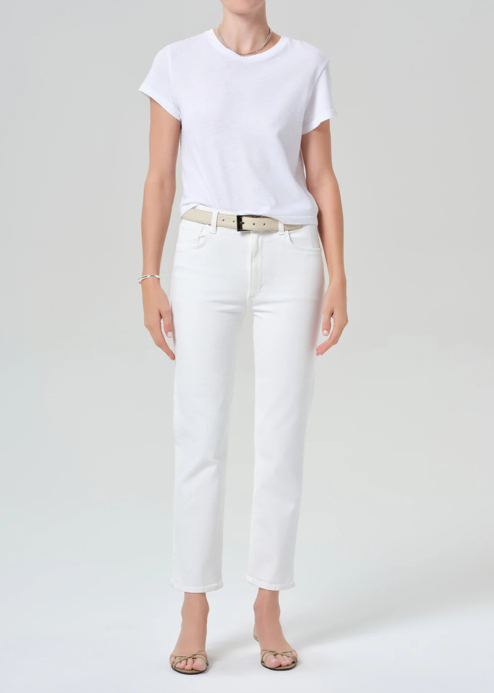 Person wearing a white t-shirt and white pants on a plain background