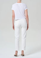 Person wearing a white t-shirt and pants on a plain background