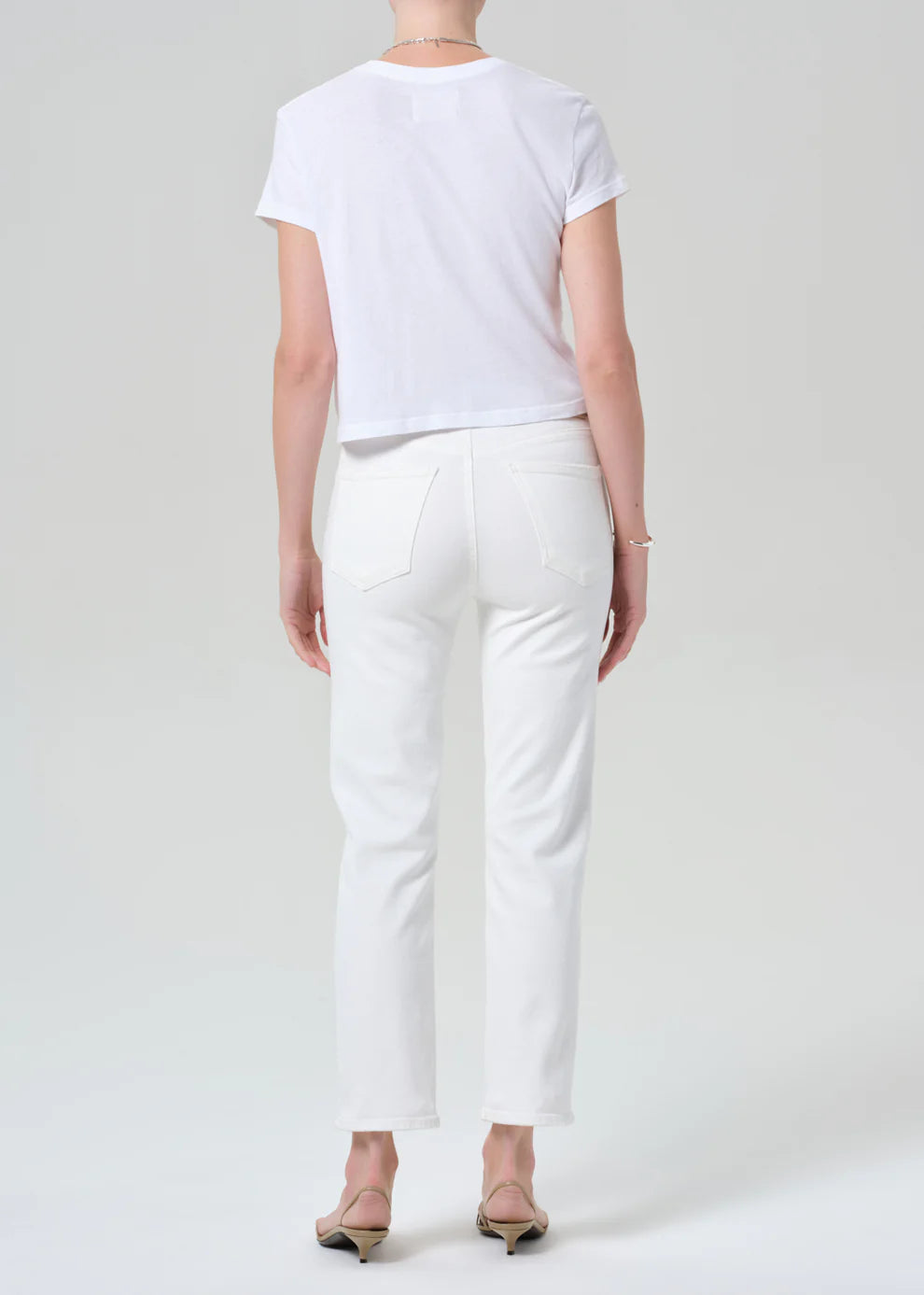 Person wearing a white t-shirt and pants on a plain background