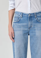 Light blue jeans worn by a person on a plain background