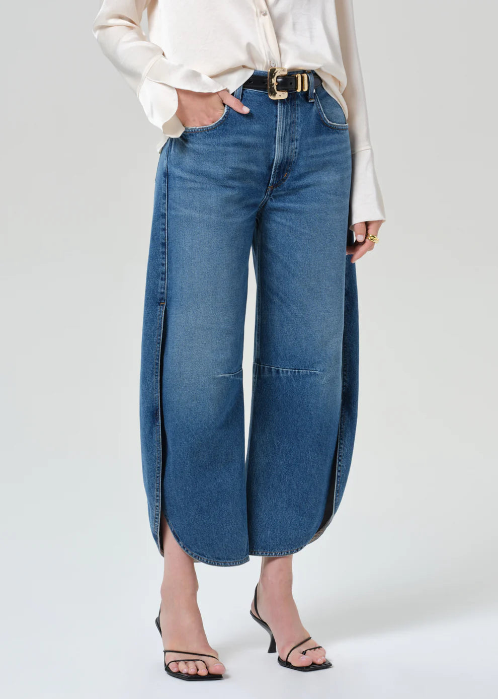 Person wearing blue wide-leg jeans on a plain background