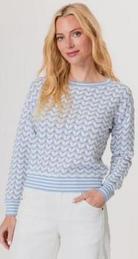 Woman wearing a light blue and white patterned sweater against a plain background