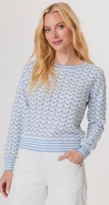 Woman wearing a light blue and white patterned sweater against a plain background