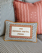 Decorative pillow with text on a striped sofa