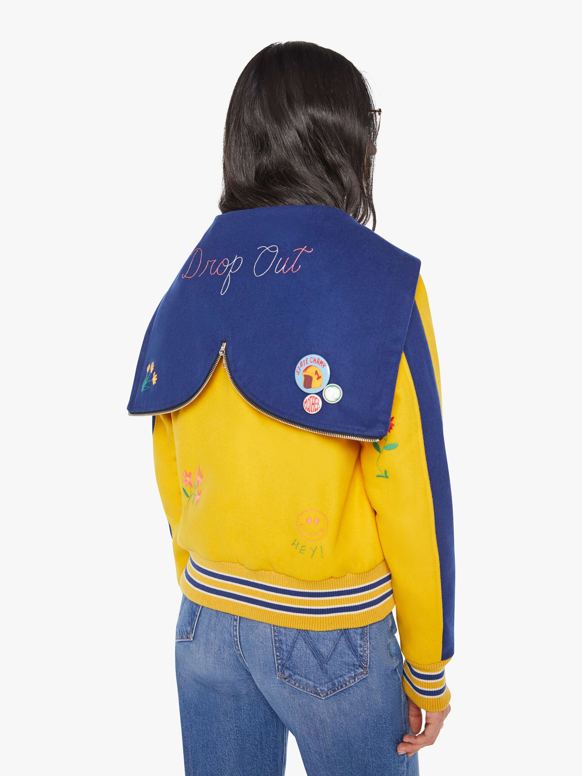 Person wearing a yellow and blue jacket with 'Drop Out' text on the back, on a white background