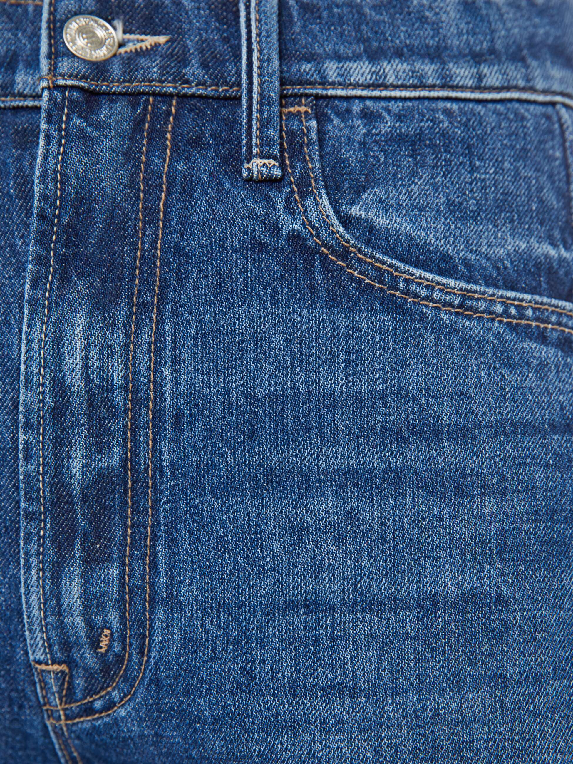 Close-up of blue denim fabric with stitching details