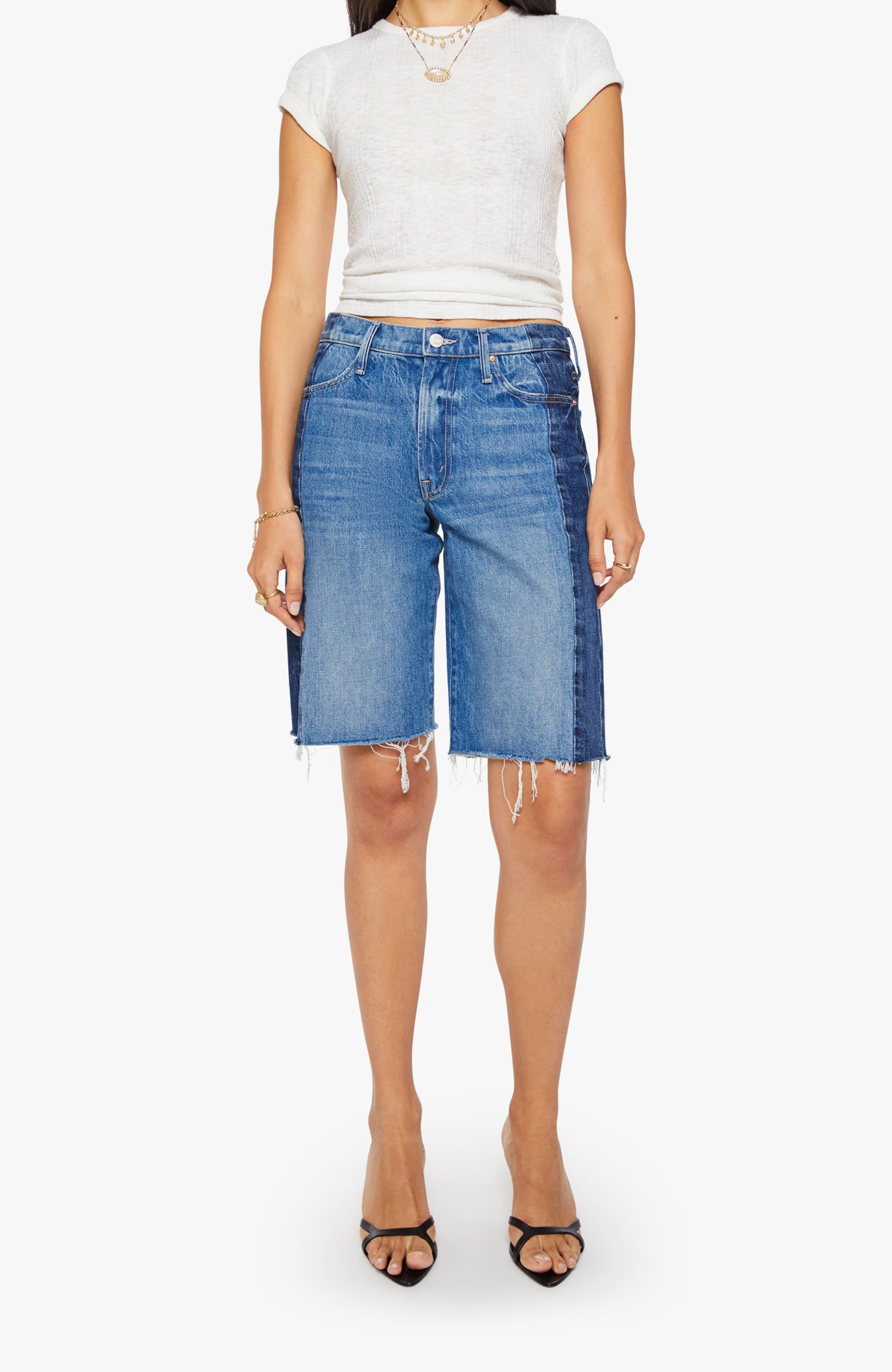 Person wearing a white top and blue denim shorts on a white background