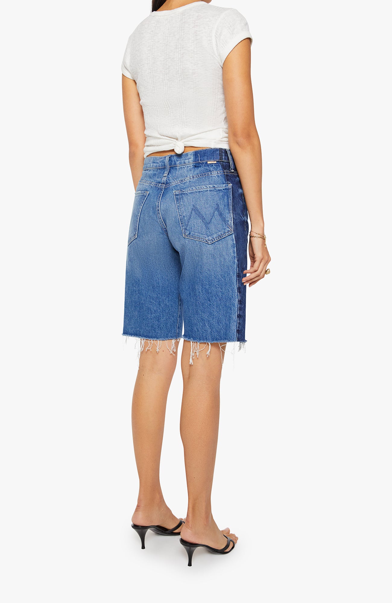 Person wearing blue denim shorts with a white background