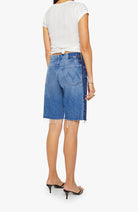 Person wearing blue denim shorts with a white background