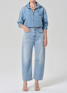 Person wearing a blue denim jacket and jeans on a white background