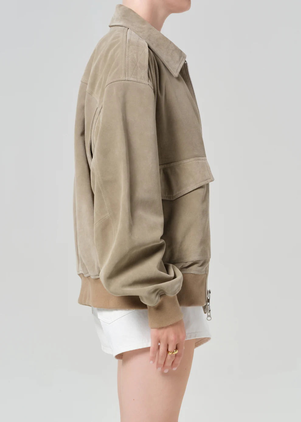 Person wearing a beige jacket on a plain background