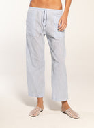 Person wearing light blue striped pajama pants on a white background