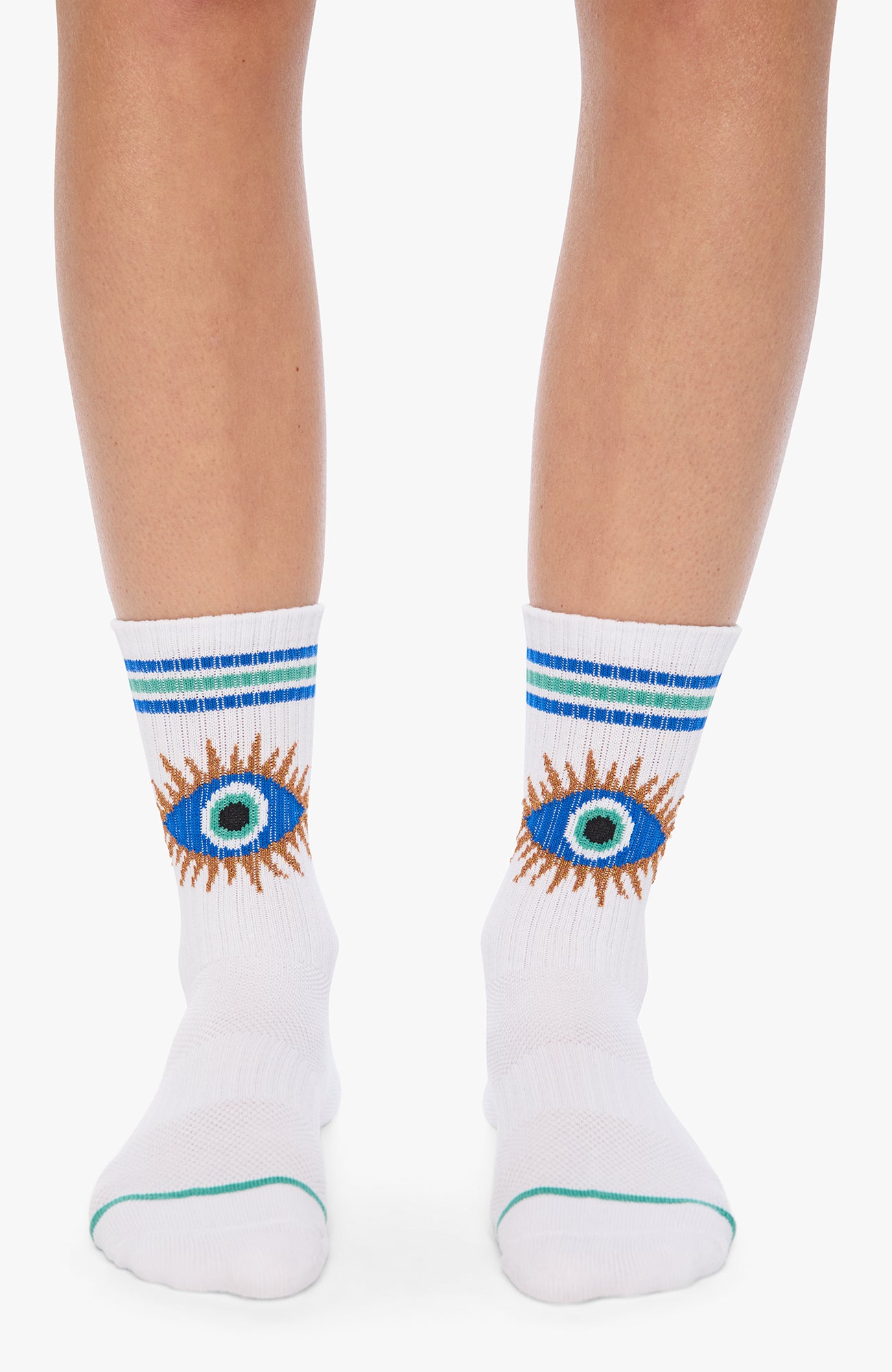 White crew socks worn on a model's feet, featuring blue and mint green stripes at the cuff and a central embroidered eye design with blue, green, and orange details.