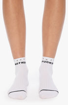 White socks with black text worn by a person on a white background