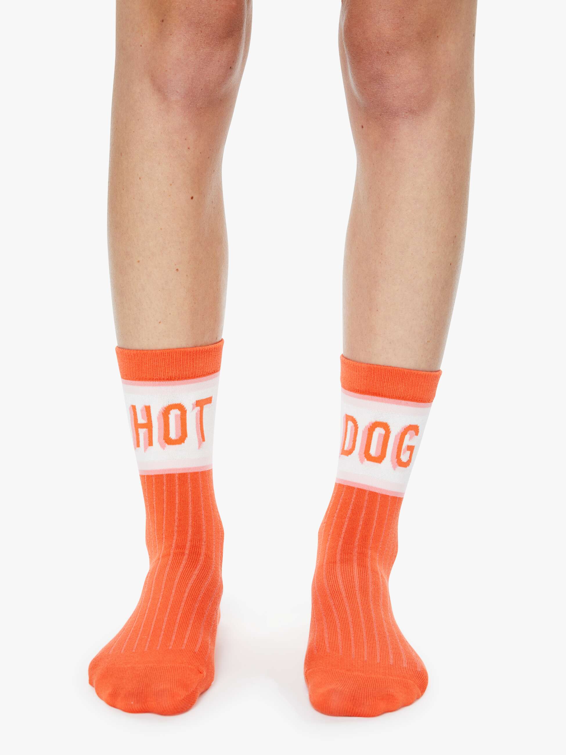 Orange socks with 'HOT DOG' text worn by a person on a white background