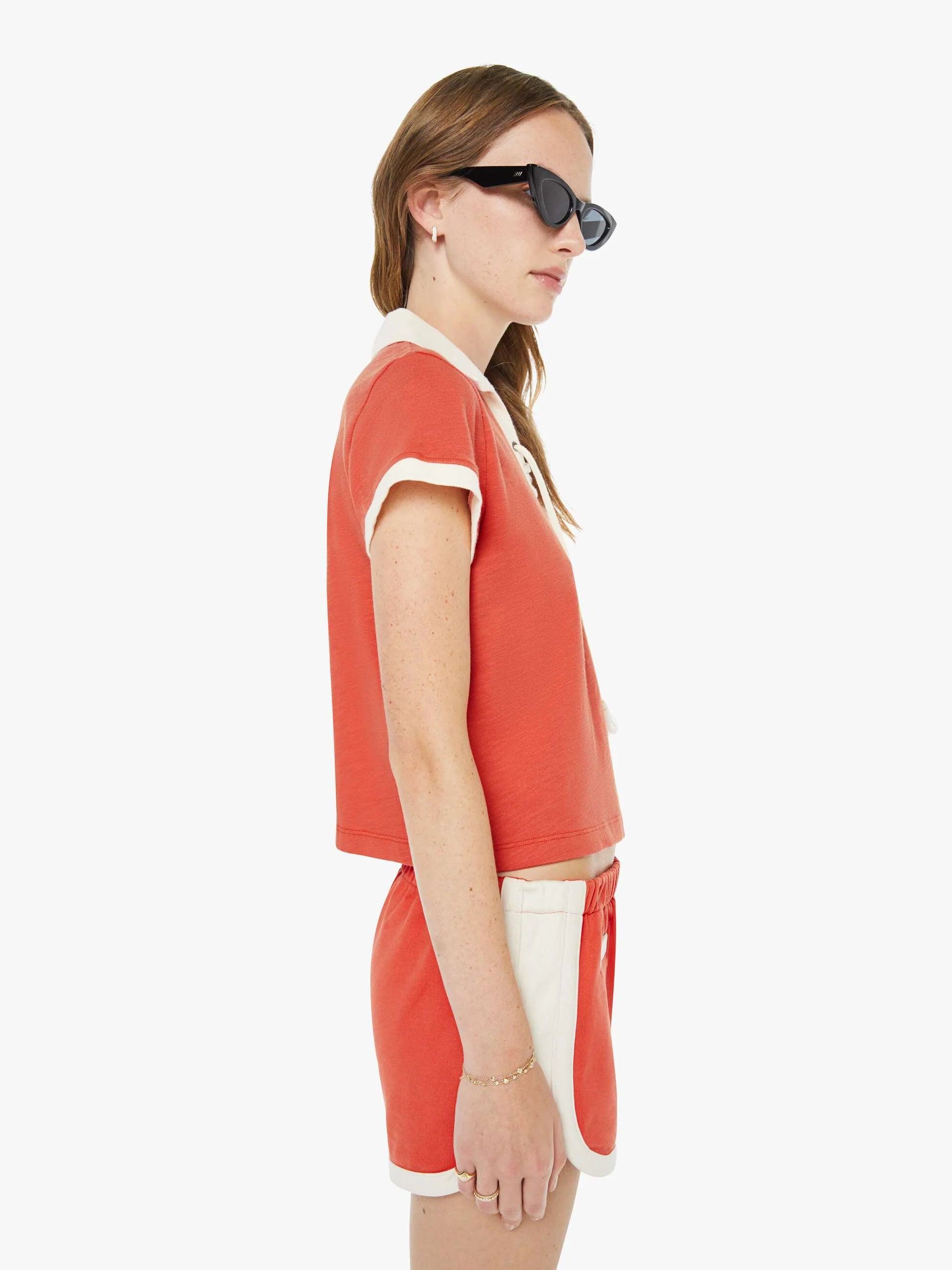 Woman wearing a red outfit with white accents on a white background