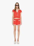 Woman wearing a red outfit with white accents on a white background