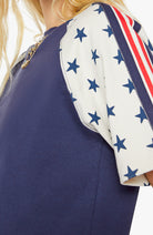 Navy dress with white sleeves featuring blue star patterns and red, white, and blue striped accents.