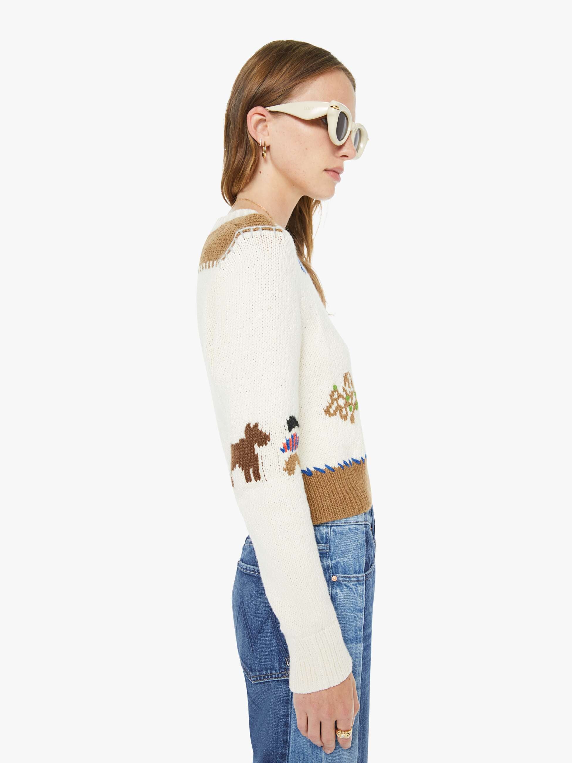 Woman wearing a patterned sweater with animal designs on a white background