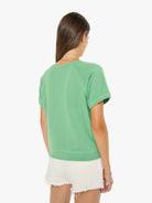 Woman wearing a green t-shirt and white shorts on a white background