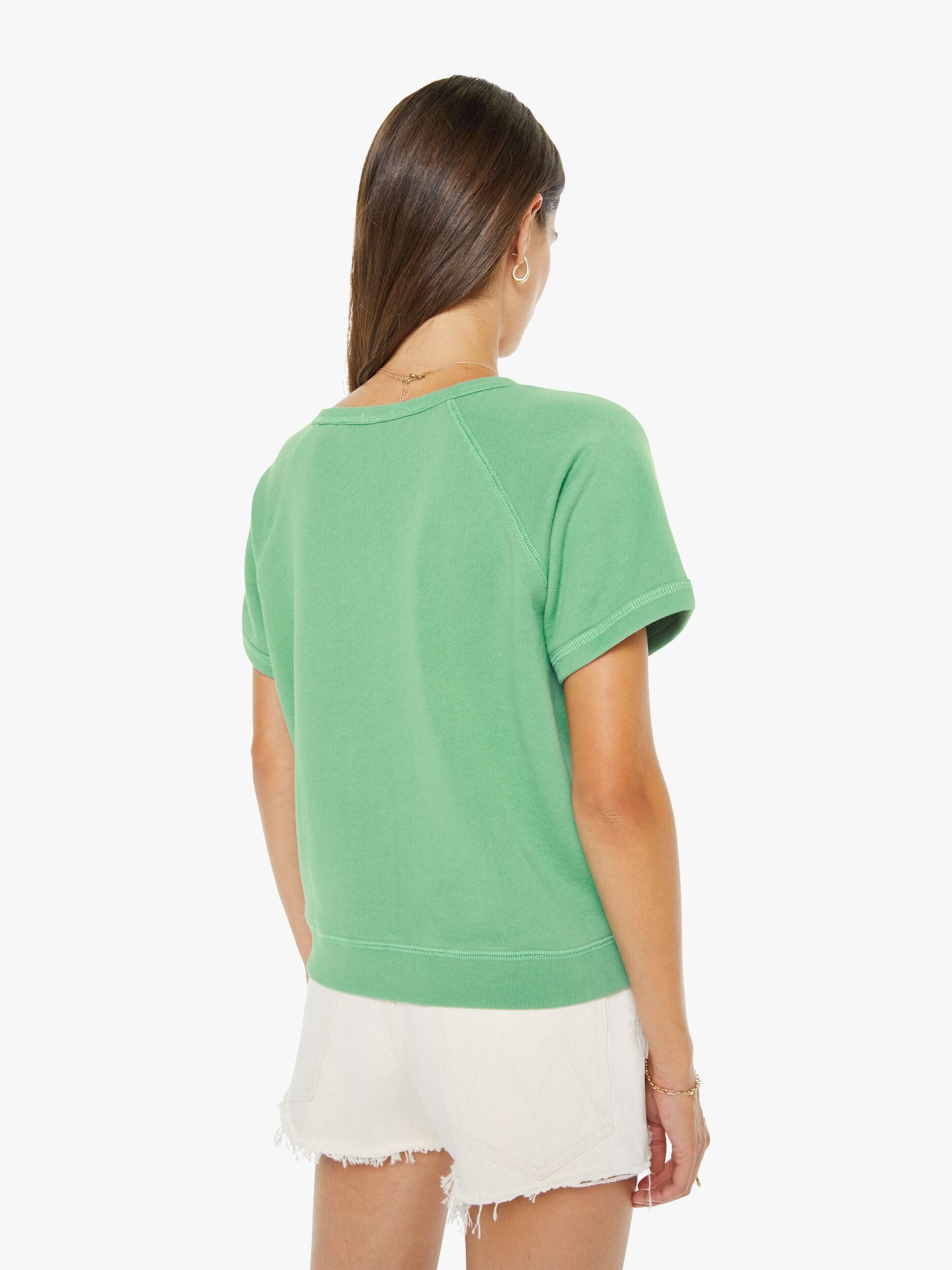 Woman wearing a green t-shirt and white shorts on a white background