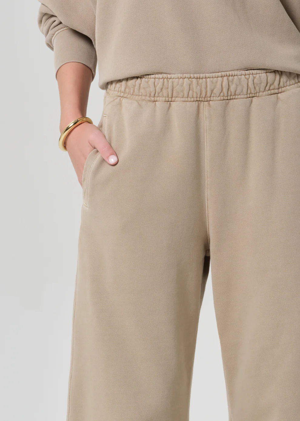 Beige sweatpants worn by a person on a plain background