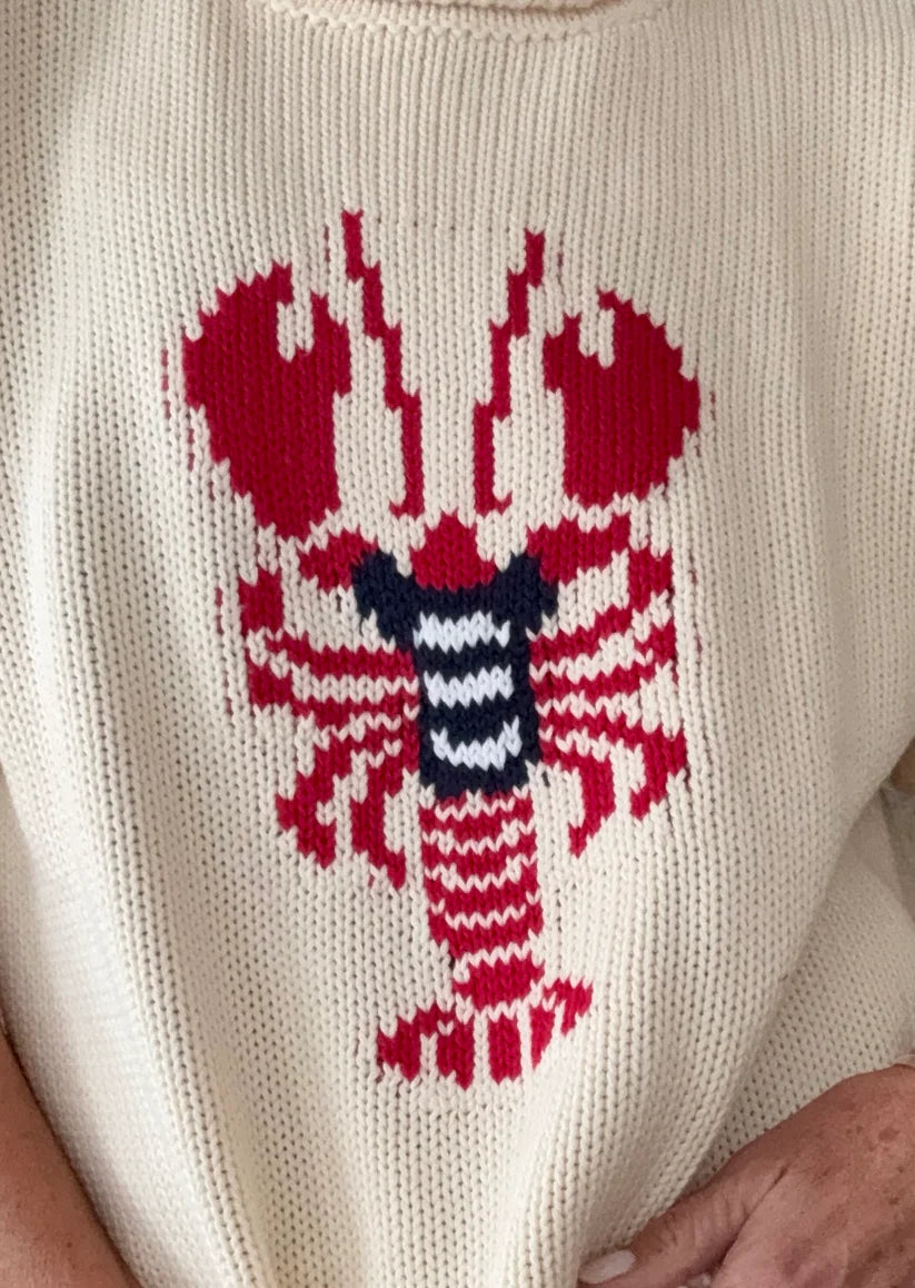 White sweater with a red lobster design on a plain background