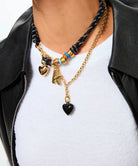 white shirt black leather jacket and a necklace and charms