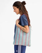 Woman holding a patterned bag against a white background