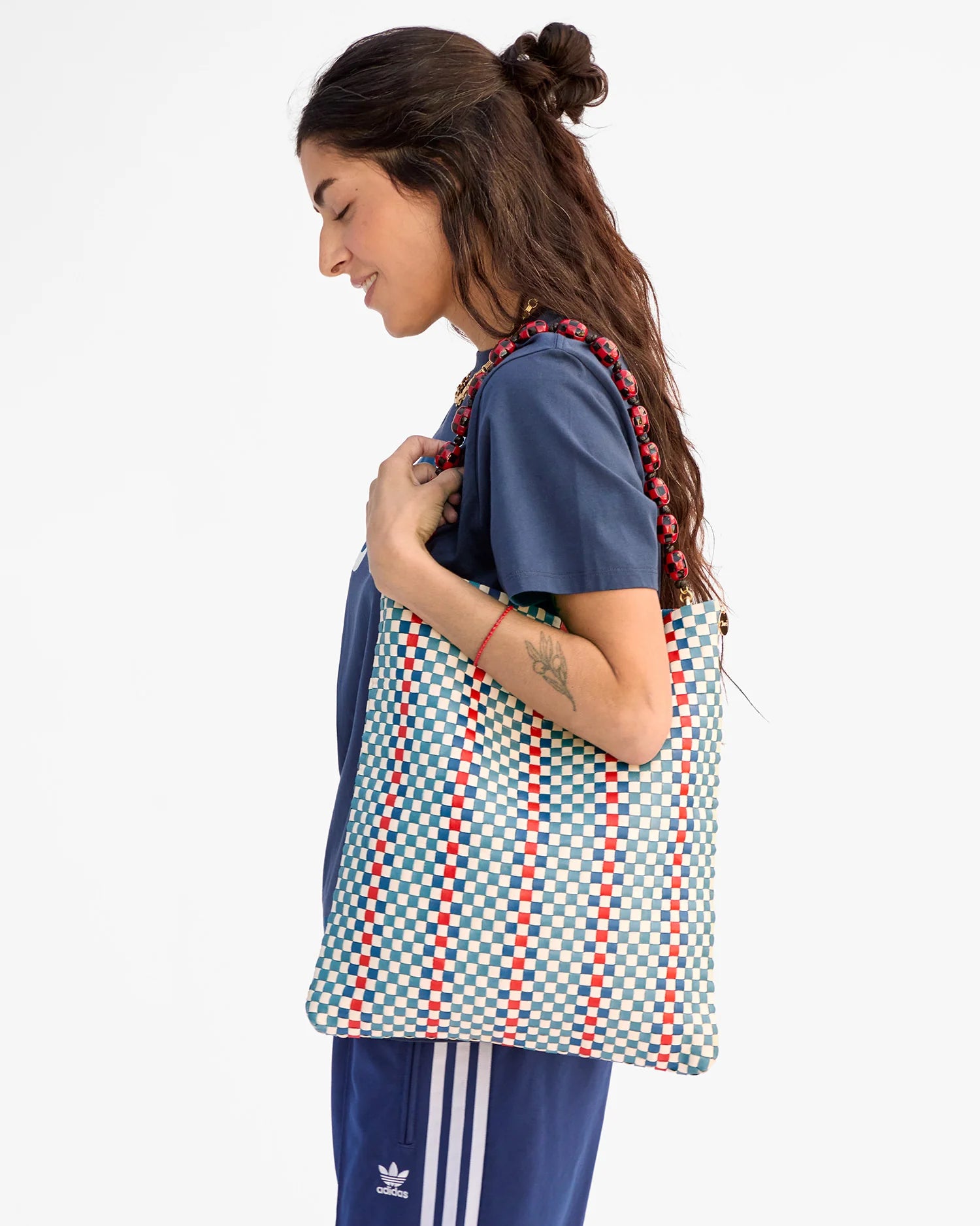 Woman holding a patterned bag against a white background