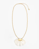 Gold necklace with a white pendant on a white background