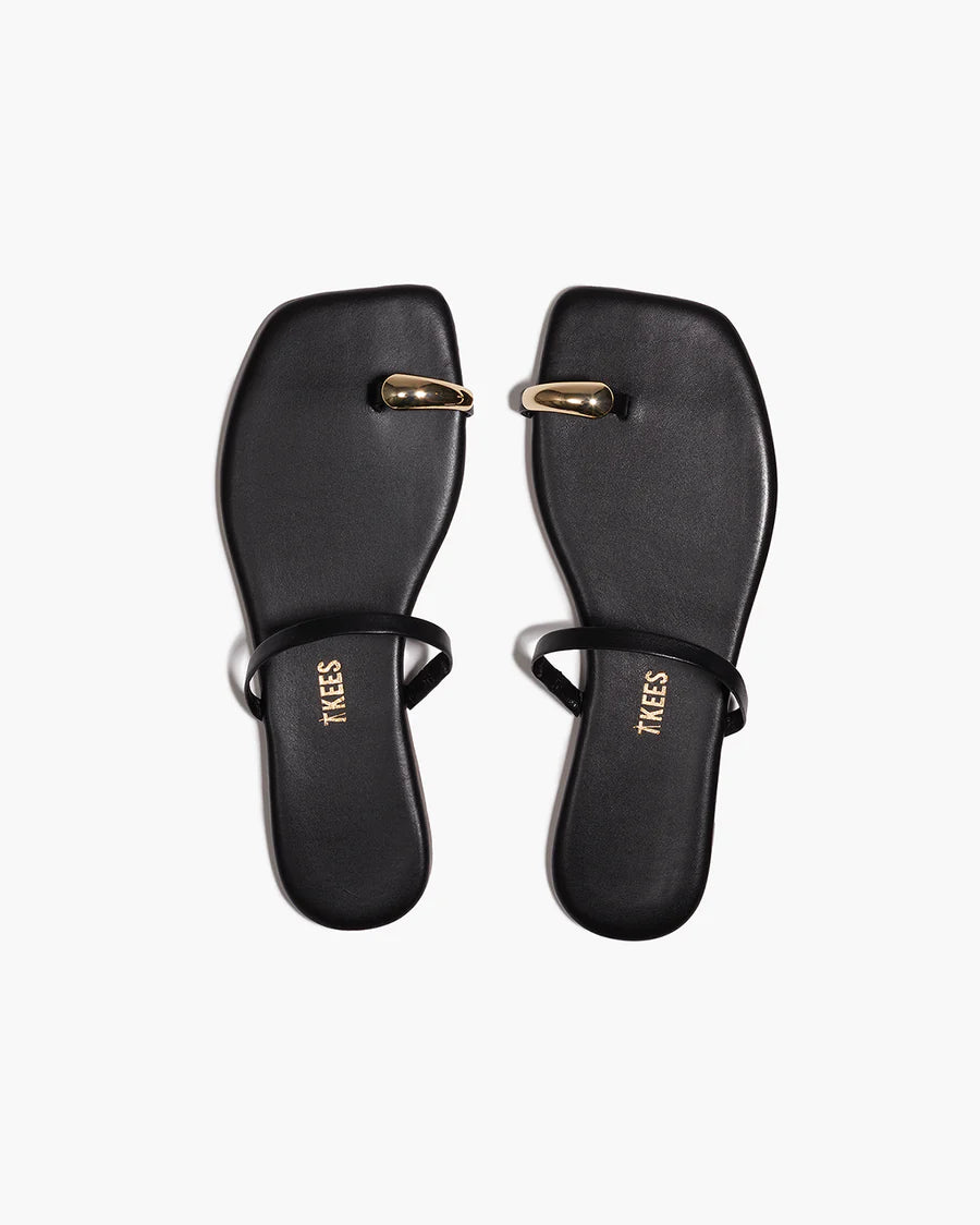 Pair of black sandals with gold accents on a white background