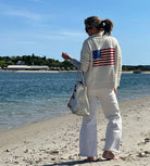 Woman on a beach wearing a sweater with an American flag design